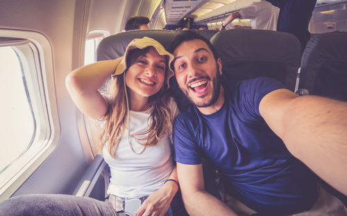 Happy Young Couple on a Plane