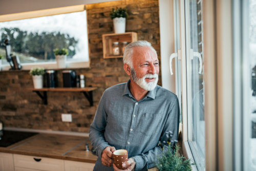 Smiling older man looking out window